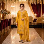 Woman wearing a golden mustard embroidered kurta pant set with a lace-trimmed dupatta