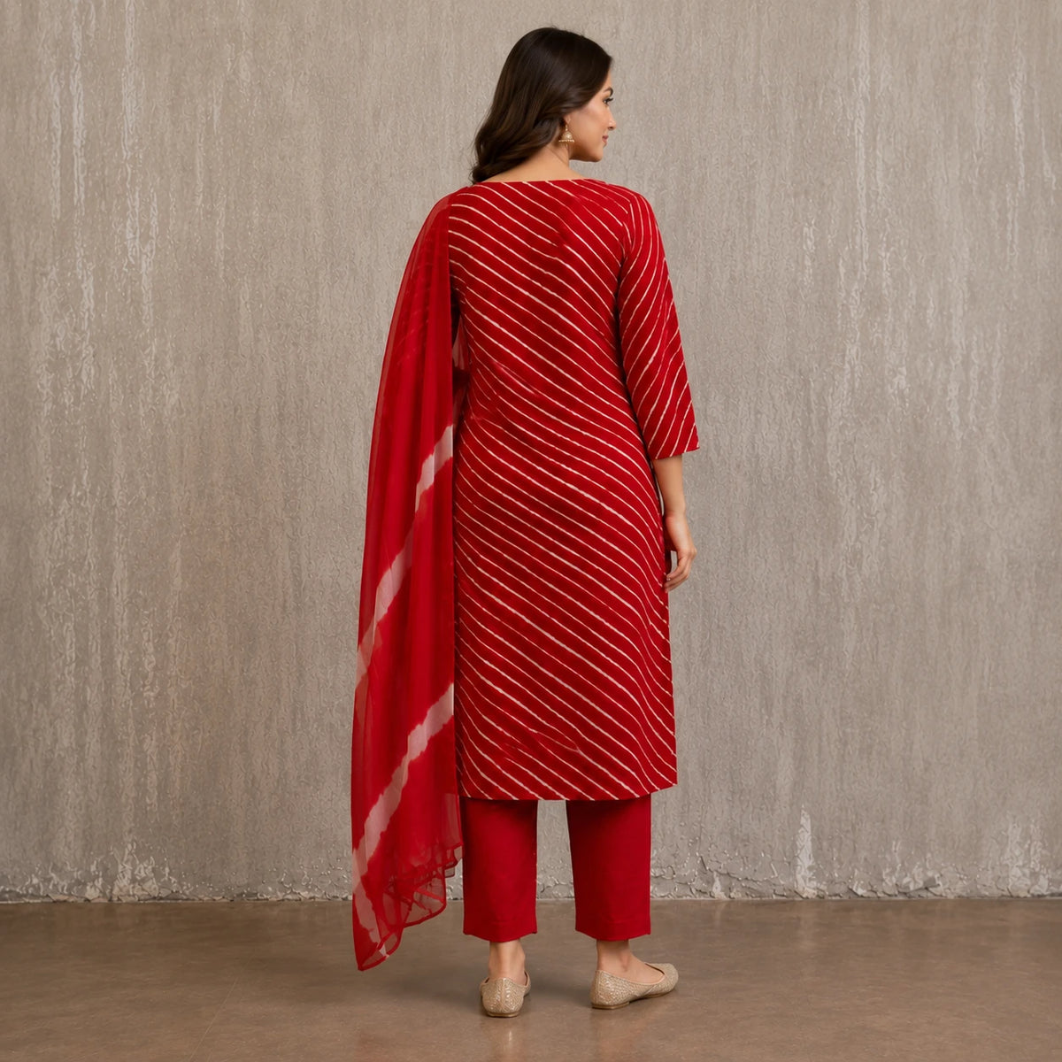Woman wearing a red printed kurta pant set with white diagonal stripes and contrast dupatta