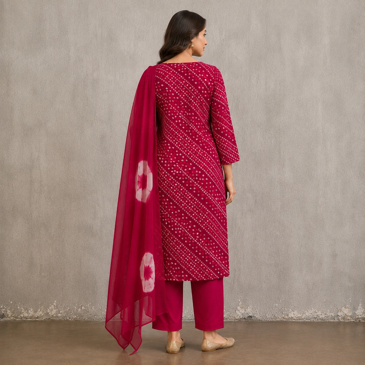 Woman wearing a magenta Bandhani-inspired printed kurta pant set with a contrast dupatta