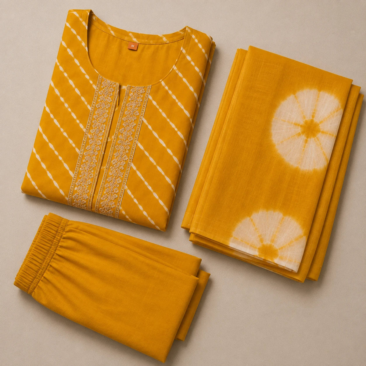 Woman wearing a mustard yellow Leheriya-inspired stripe kurta pant set with a tie-dye dupatta