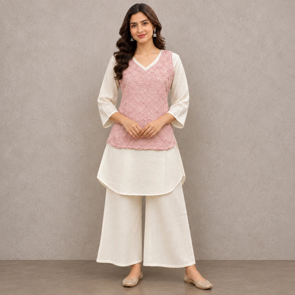 Woman wearing a blush pink floral embroidered peplum kurta with ivory inner top and wide-leg palazzo pants