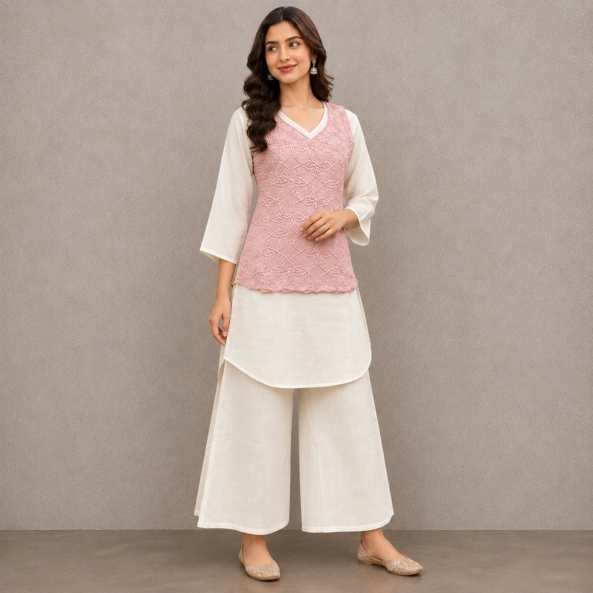 Woman wearing a blush pink floral embroidered peplum kurta with ivory inner top and wide-leg palazzo pants