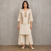 Woman wearing an ivory mirror embroidered V-neck kurta with wide-leg palazzo pants