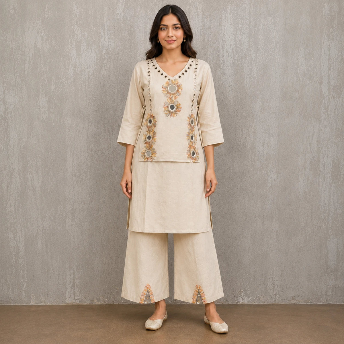 Woman wearing an ivory mirror embroidered V-neck kurta with wide-leg palazzo pants