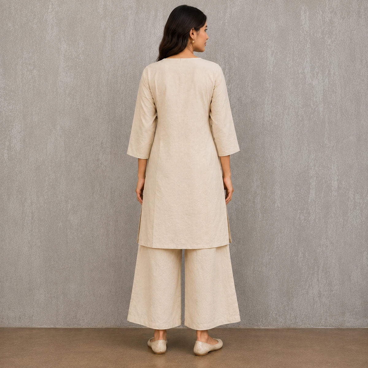 Woman wearing an ivory mirror embroidered V-neck kurta with wide-leg palazzo pants