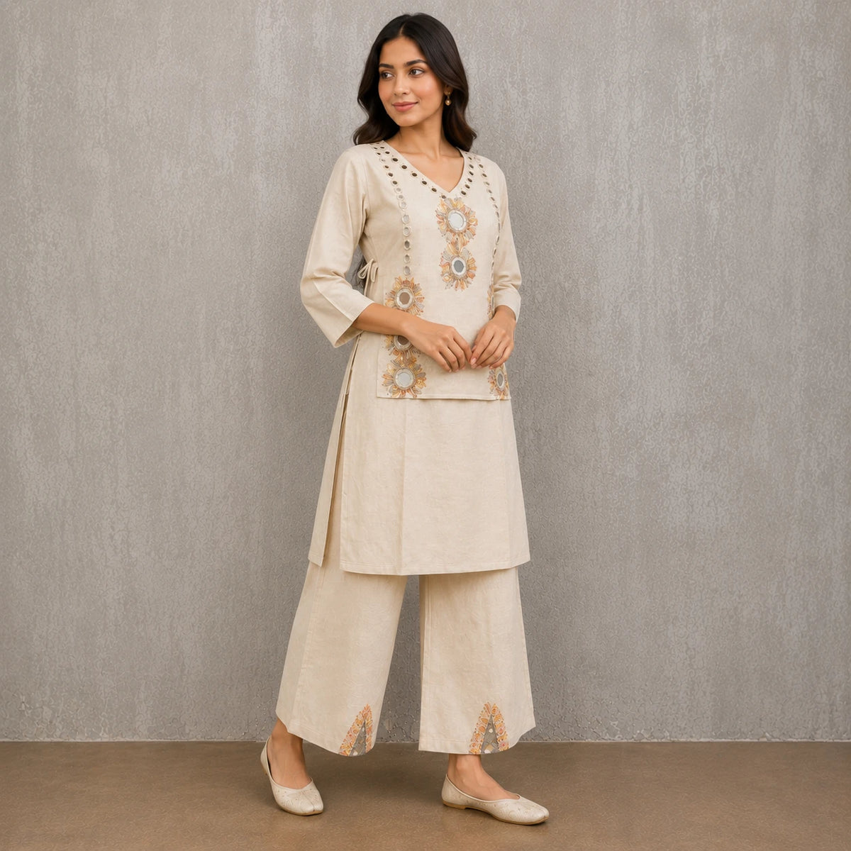 Woman wearing an ivory mirror embroidered V-neck kurta with wide-leg palazzo pants