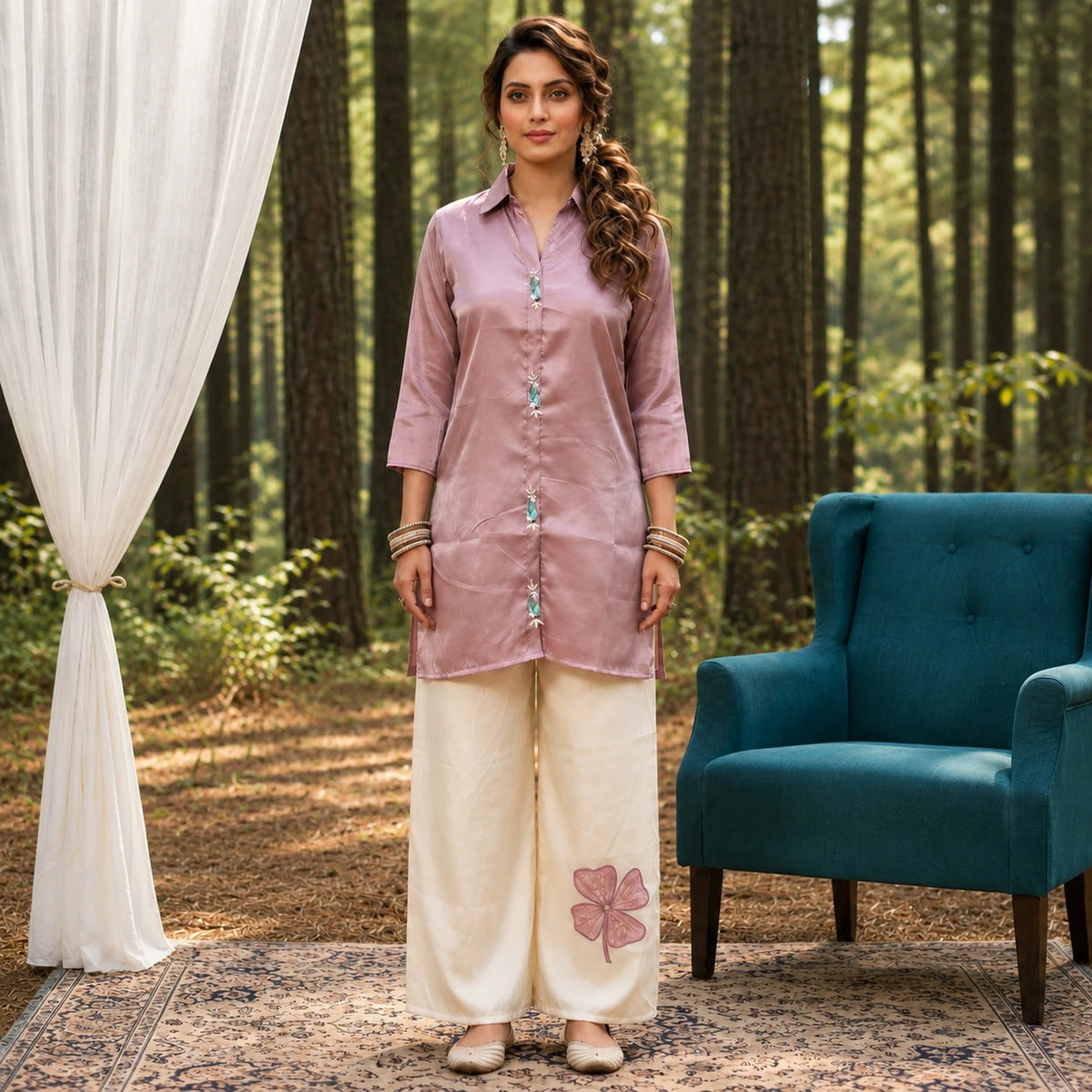 Woman wearing a dusty rose long shirt with decorative front embellishment and ivory wide-leg pants
